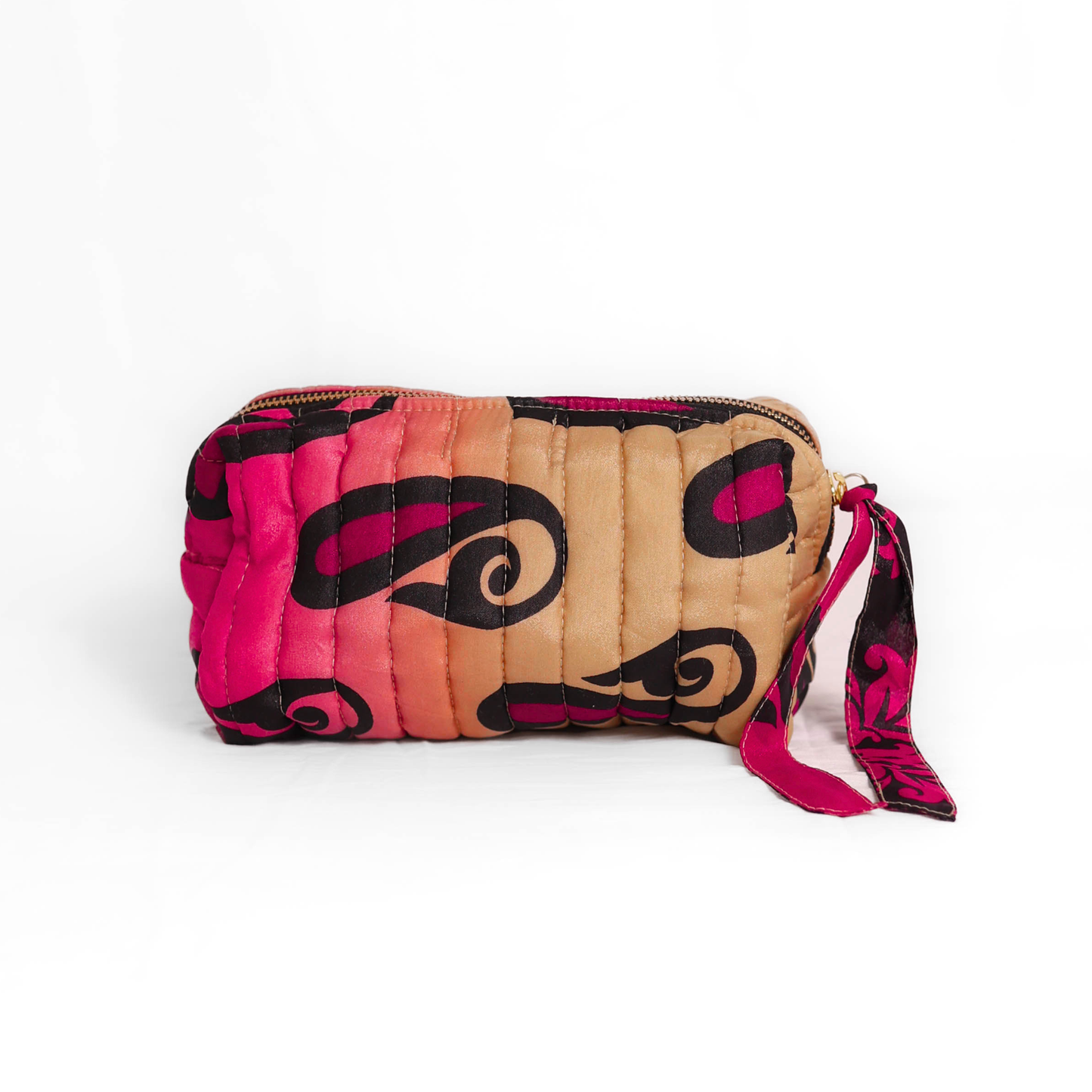 Quilted dumpling bag made from repurposed vintage sari fabric with stitched detailing and a structured rectangular shape. The bag features a zip closure and a fabric tie