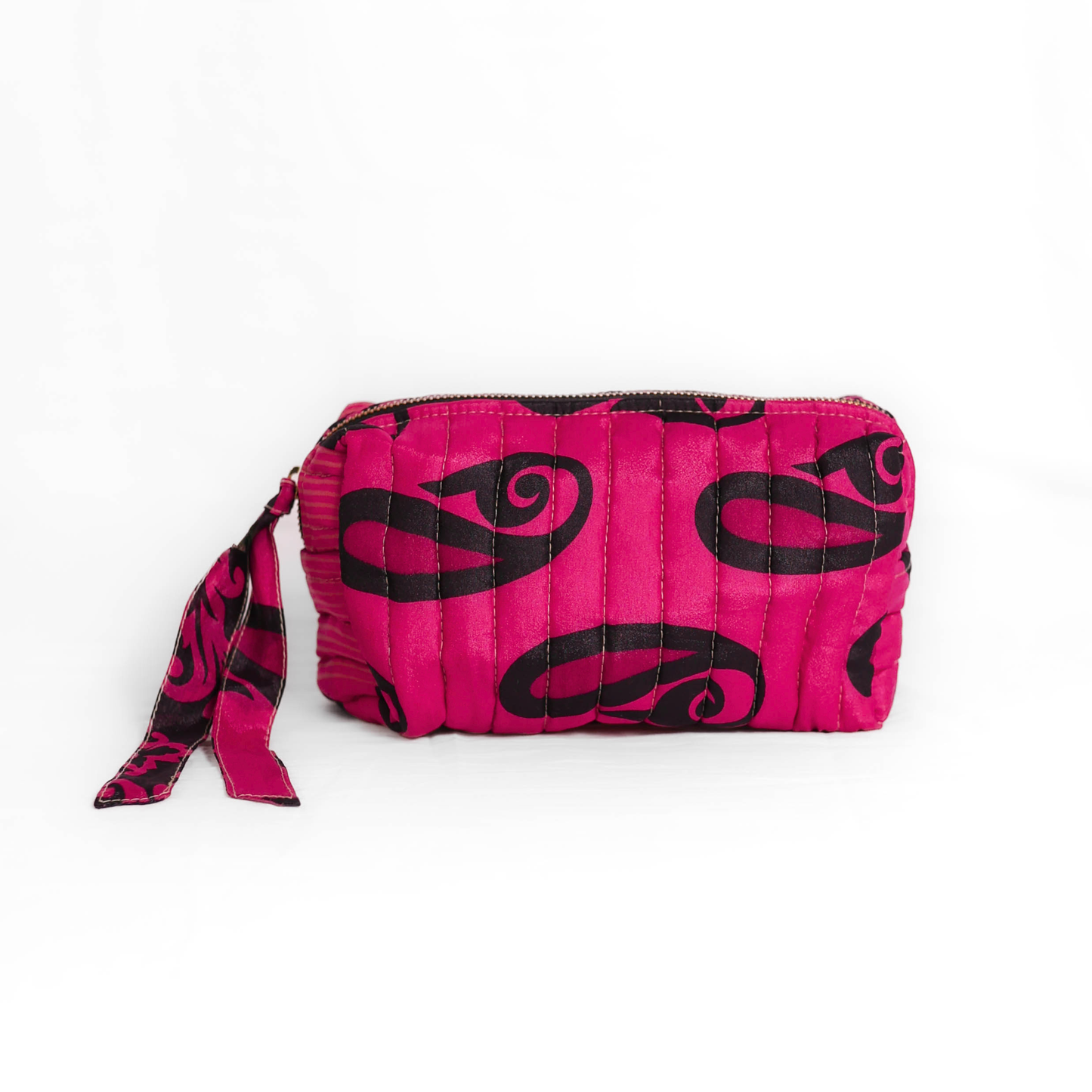 Quilted dumpling bag made from repurposed vintage sari fabric with stitched detailing and a structured rectangular shape. The bag features a zip closure and a fabric tie