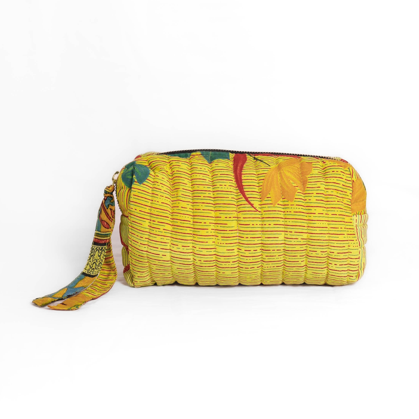 Quilted dumpling bag made from repurposed vintage sari fabric with stitched detailing and a structured rectangular shape. The bag features a zip closure and a fabric tie