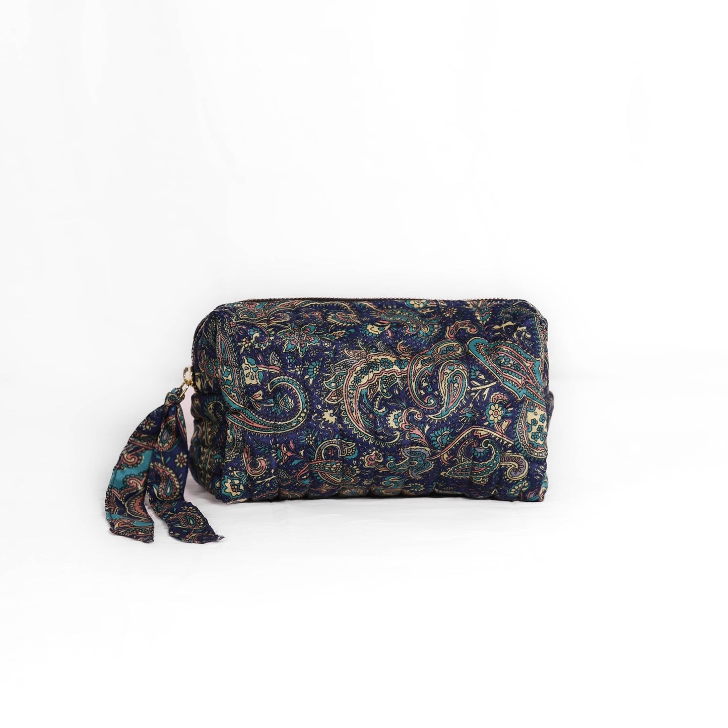 Quilted dumpling bag made from repurposed vintage sari fabric with stitched detailing and a structured rectangular shape. The bag features a zip closure and a fabric tie