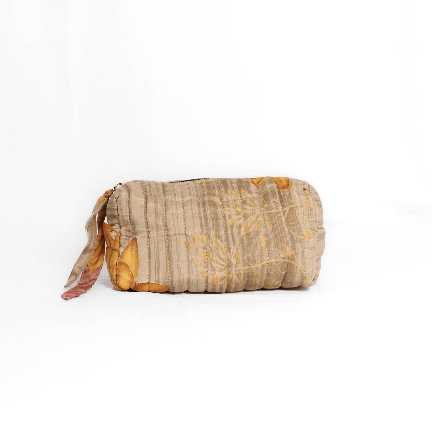 Quilted dumpling bag made from repurposed vintage sari fabric with stitched detailing and a structured rectangular shape. The bag features a zip closure and a fabric tie