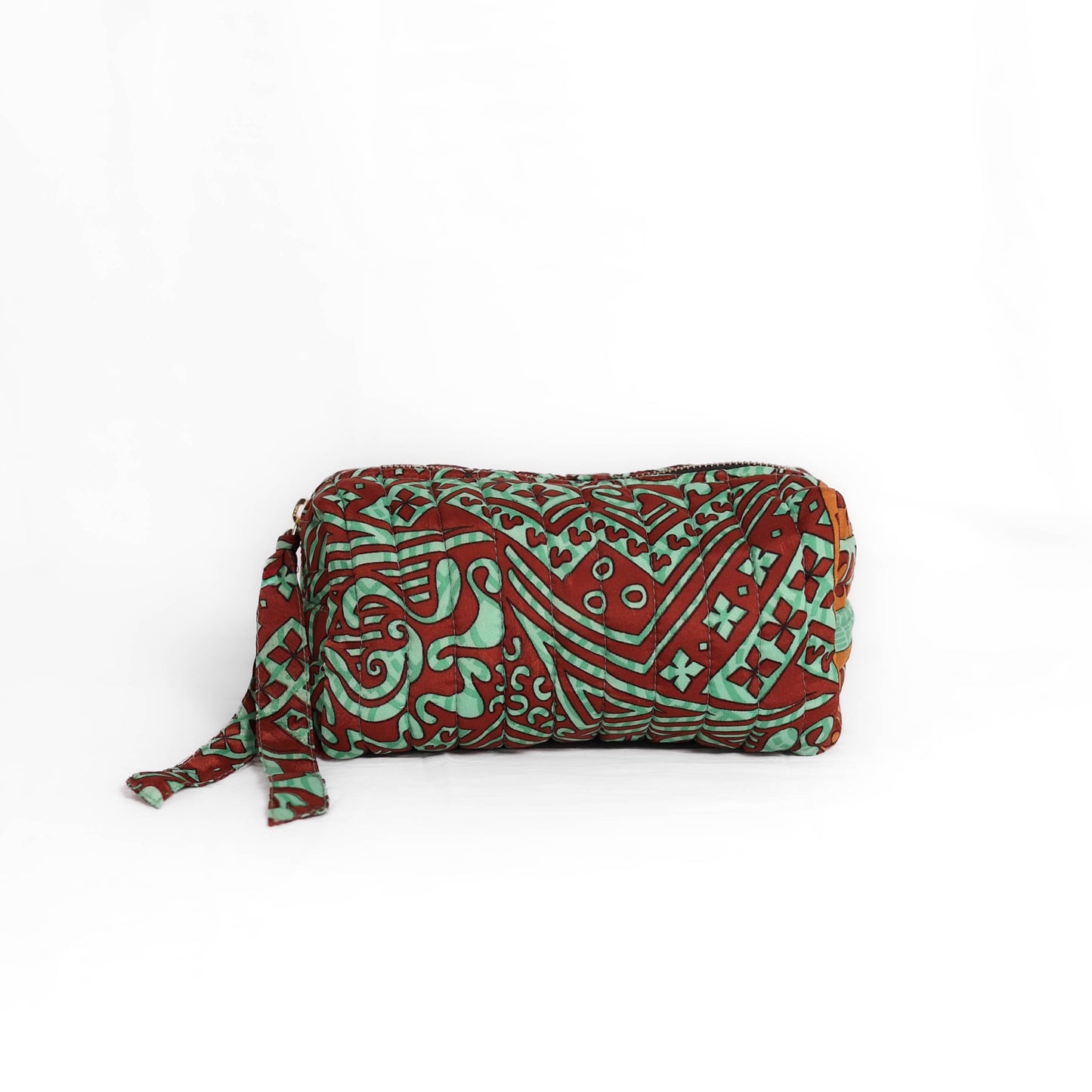 Quilted dumpling bag made from repurposed vintage sari fabric with stitched detailing and a structured rectangular shape. The bag features a zip closure and a fabric tie