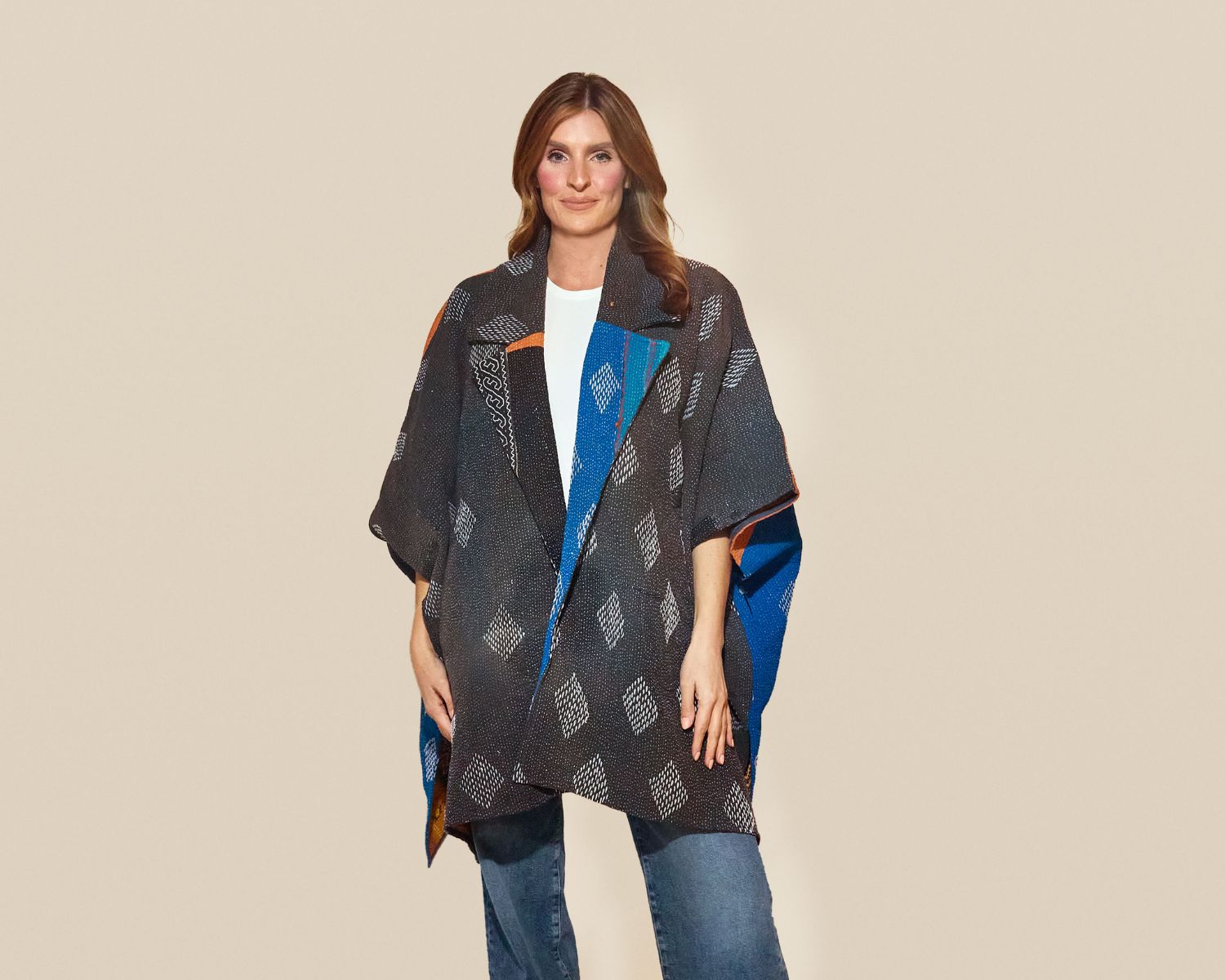 Mid-length open-front jacket with wide sleeves, made from a dark gray woven textile featuring small white diamond motifs and contrasting blue and orange panels.
