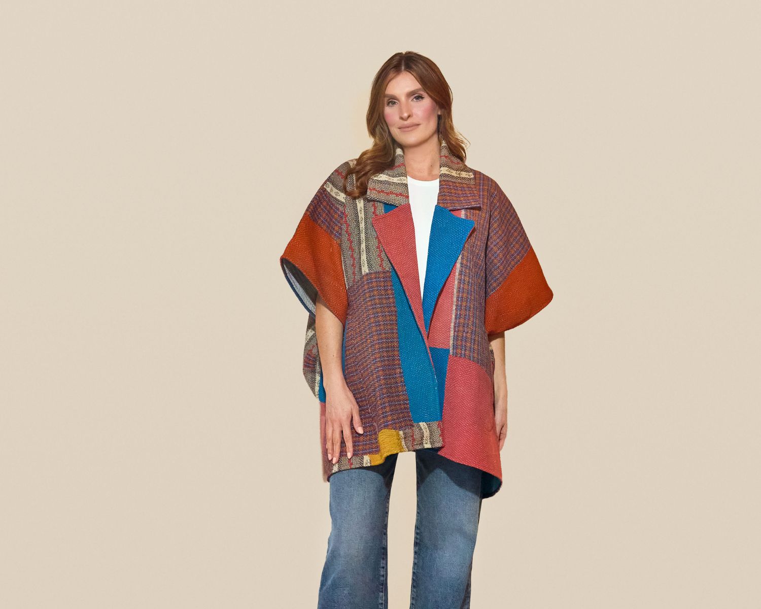 Mid-length open-front jacket with wide sleeves, constructed from multicolored patchwork woven textiles in rust, blue, and purple with varied stripe and geometric patterns.