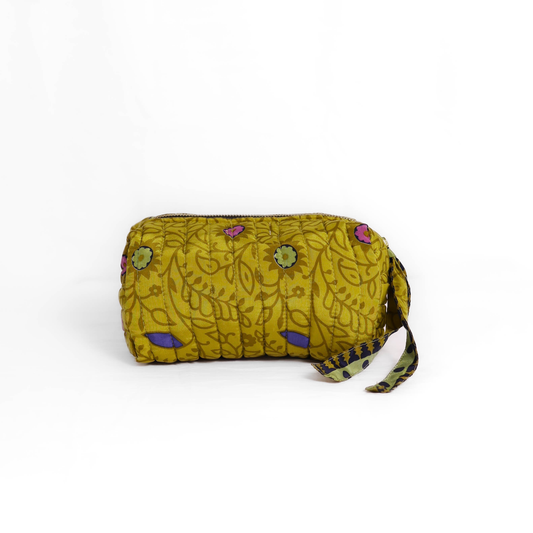 Quilted dumpling bag made from repurposed vintage sari fabric with stitched detailing and a structured rectangular shape. The bag features a zip closure and a fabric tie
