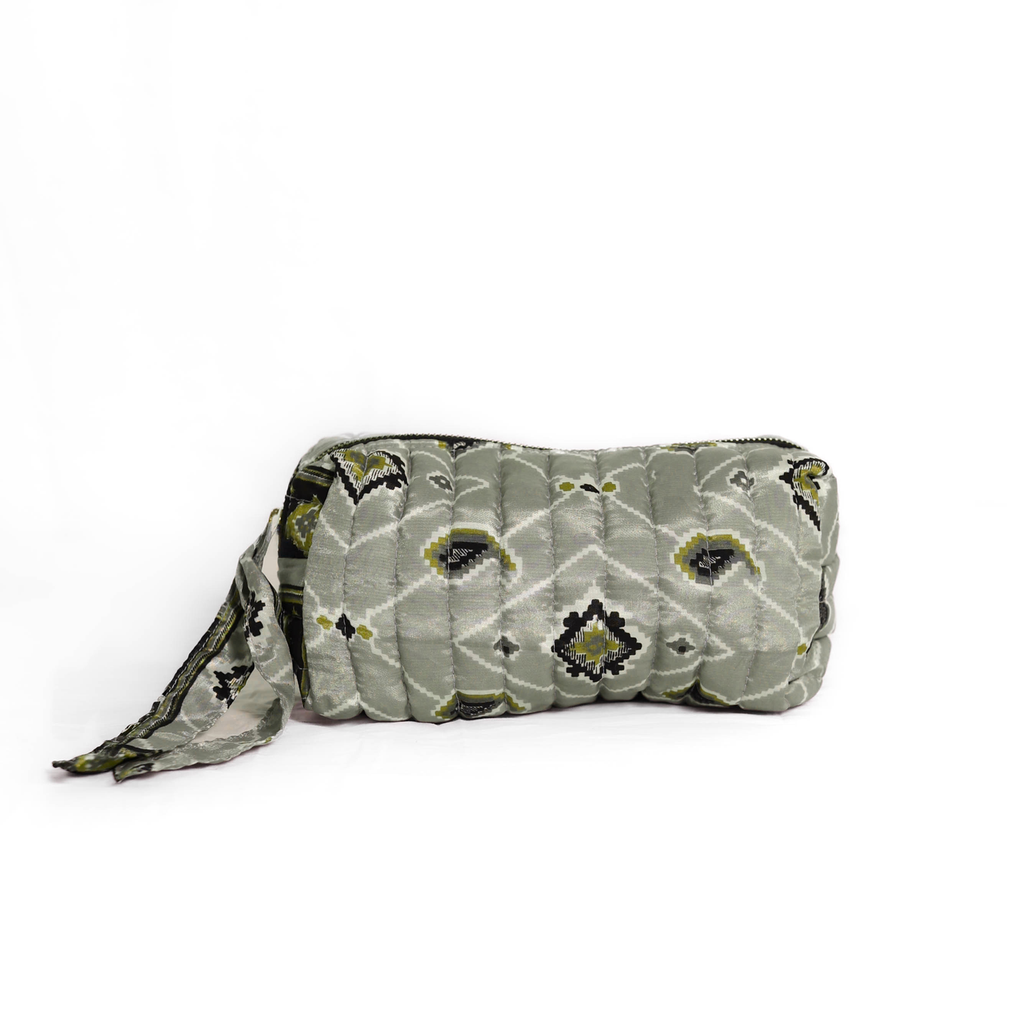 Quilted dumpling bag made from repurposed vintage sari fabric with stitched detailing and a structured rectangular shape. The bag features a zip closure and a fabric tie
