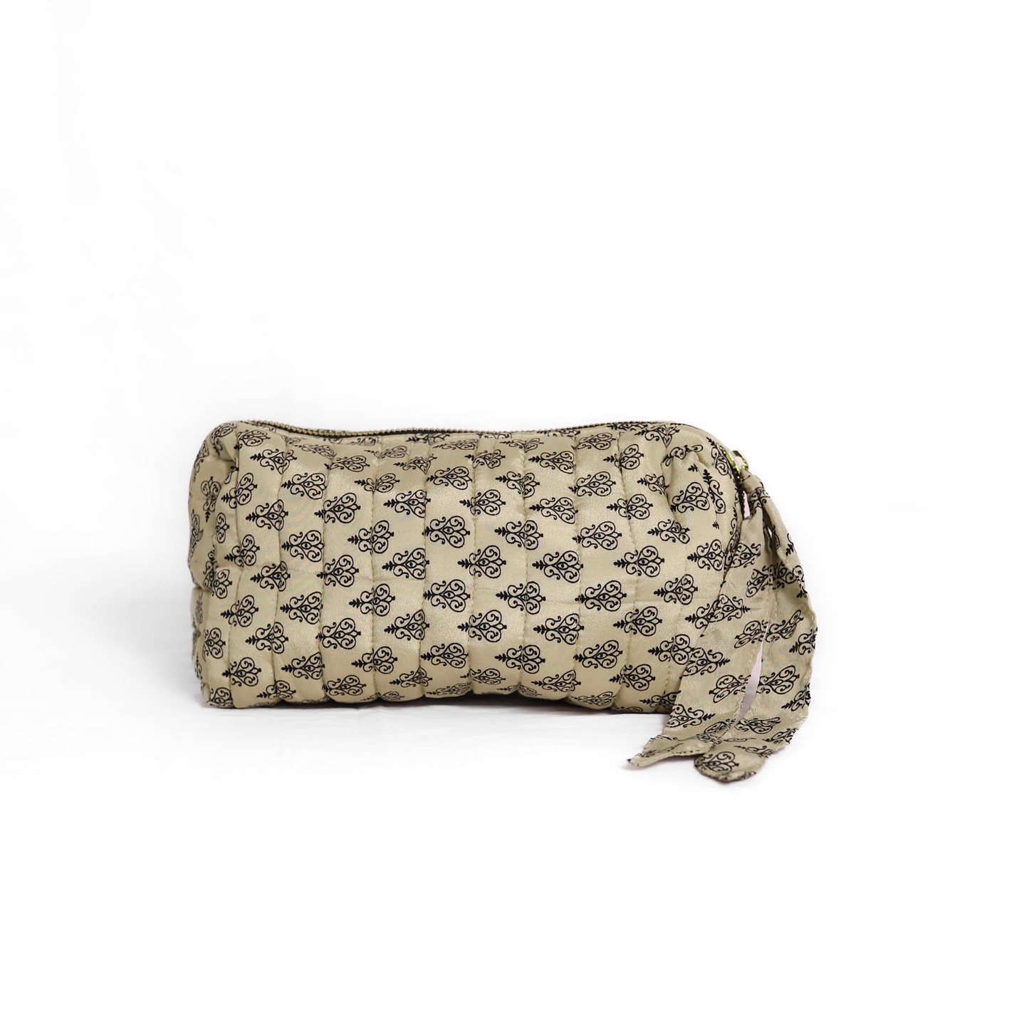 Quilted dumpling bag made from repurposed vintage sari fabric with stitched detailing and a structured rectangular shape. The bag features a zip closure and a fabric tie
