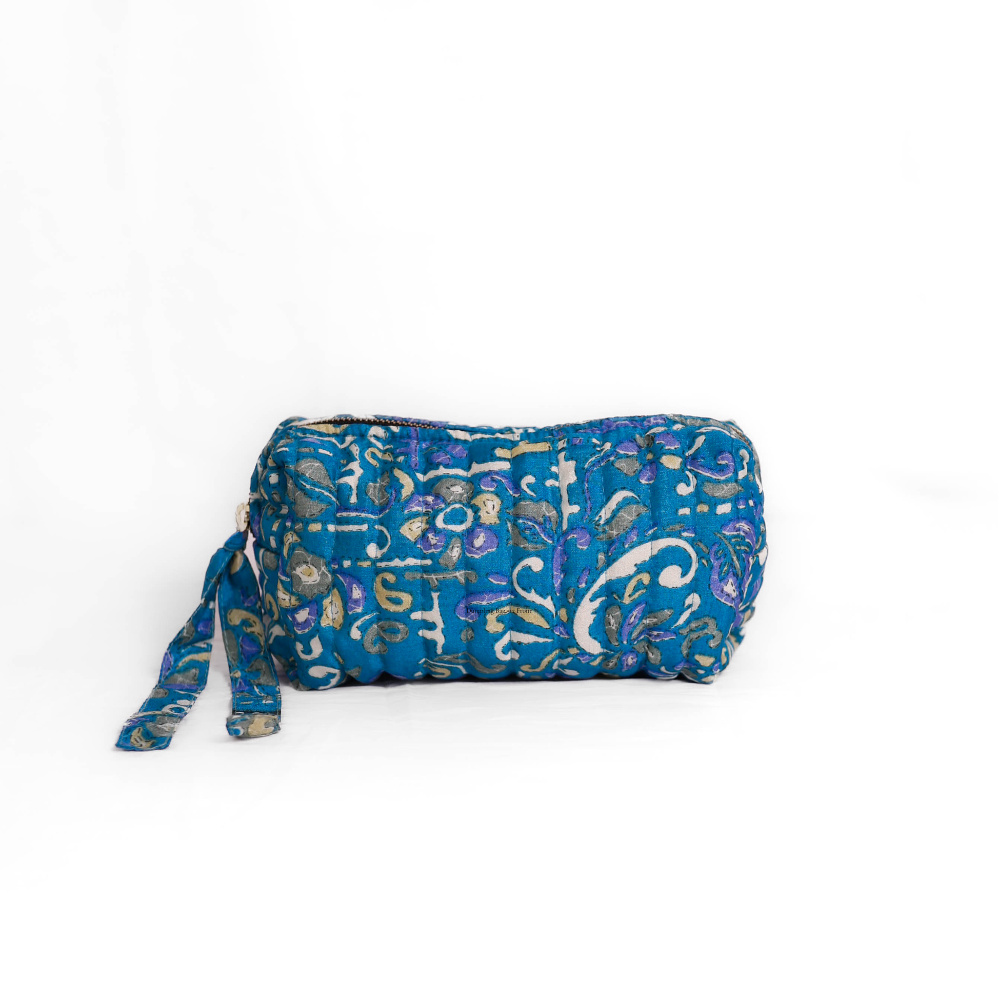 Quilted dumpling bag made from repurposed vintage sari fabric with stitched detailing and a structured rectangular shape. The bag features a zip closure and a fabric tie
