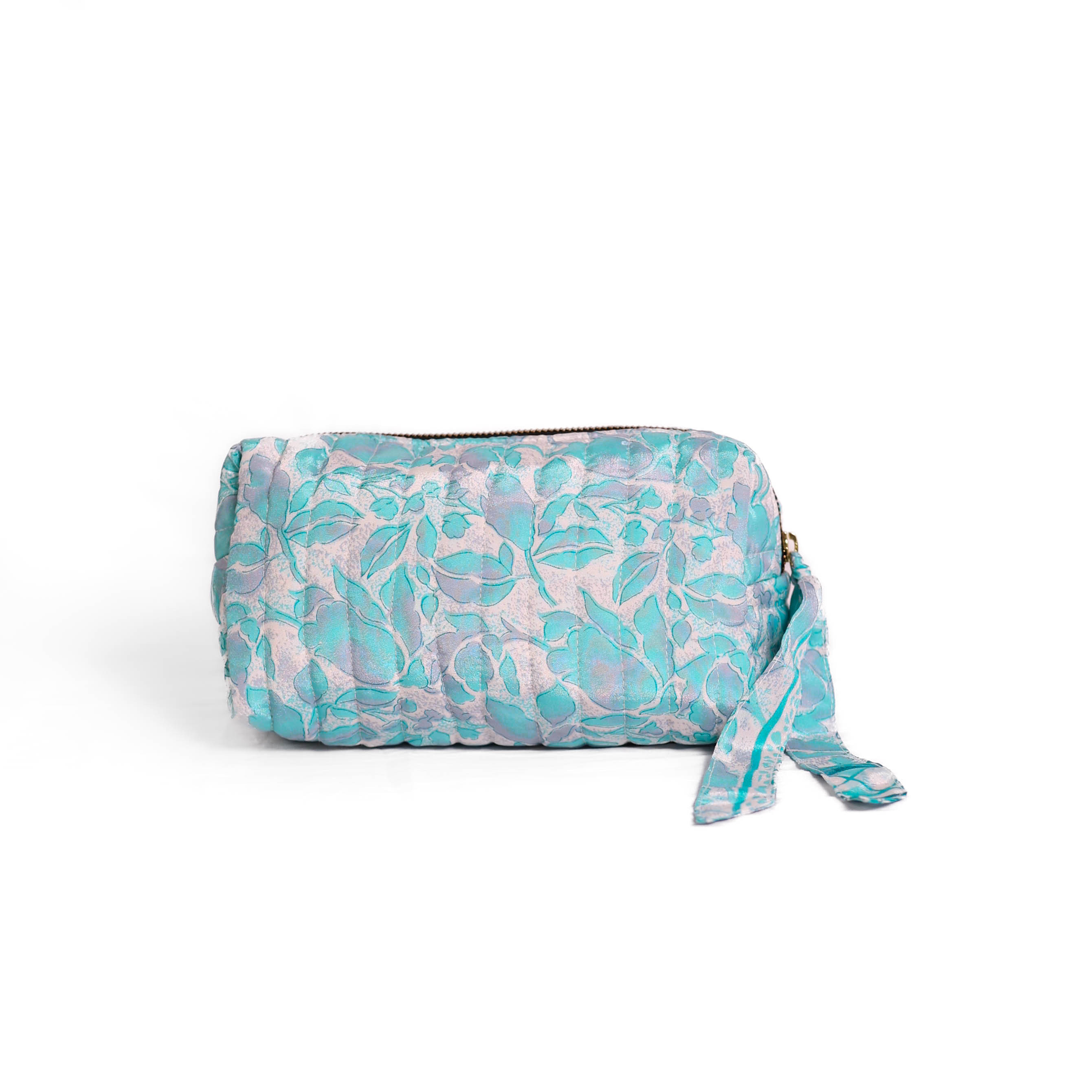 Quilted dumpling bag made from repurposed vintage sari fabric with stitched detailing and a structured rectangular shape. The bag features a zip closure and a fabric tie
