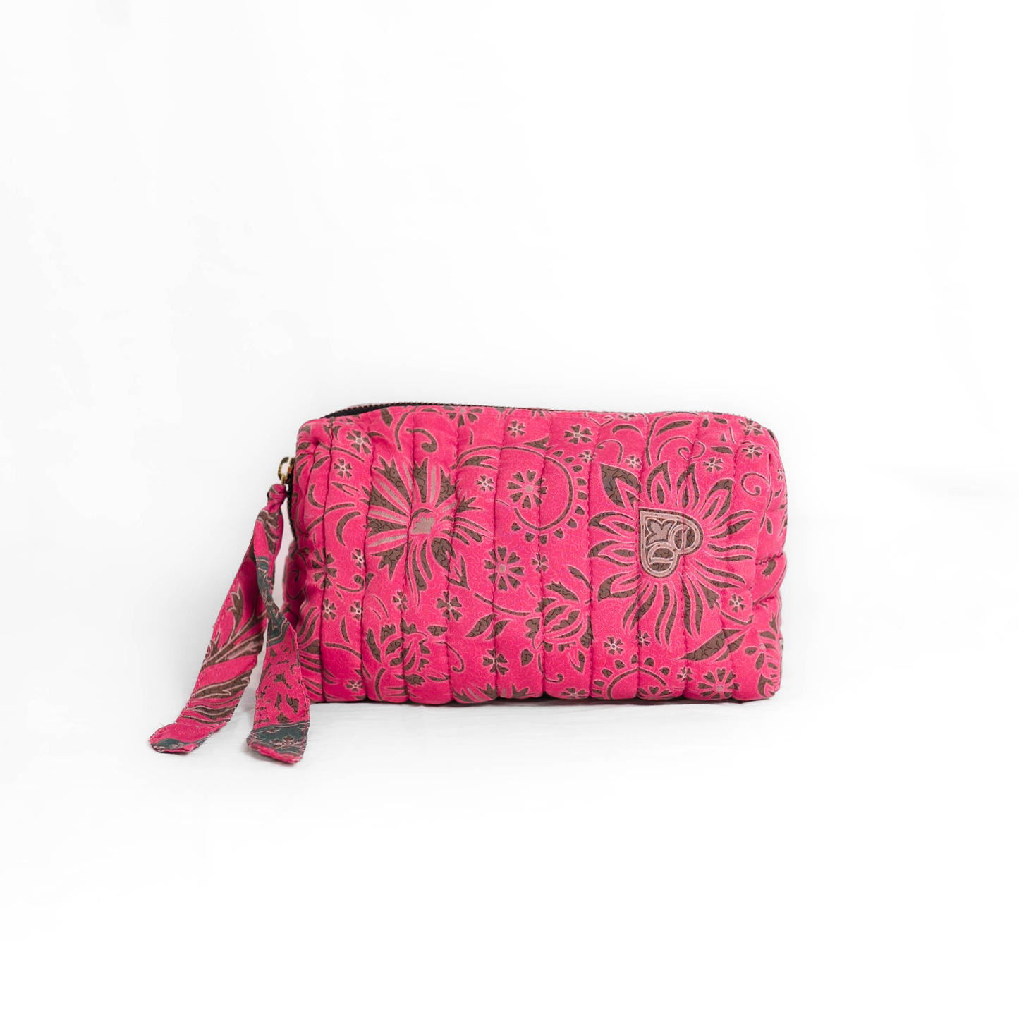 Quilted dumpling bag made from repurposed vintage sari fabric with stitched detailing and a structured rectangular shape. The bag features a zip closure and a fabric tie
