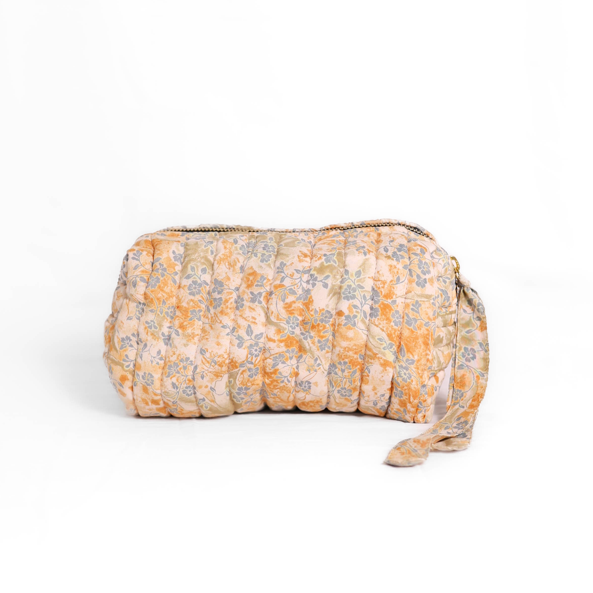 Quilted dumpling bag made from repurposed vintage sari fabric with stitched detailing and a structured rectangular shape. The bag features a zip closure and a fabric tie