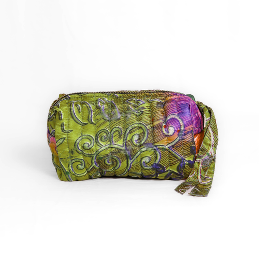 Quilted dumpling bag made from repurposed vintage sari fabric with stitched detailing and a structured rectangular shape. The bag features a zip closure and a fabric tie