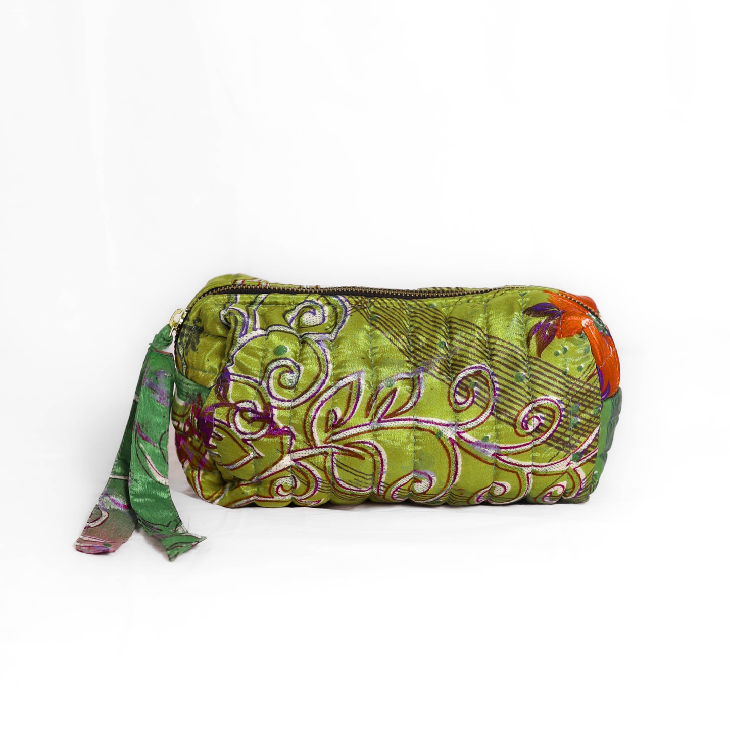 Quilted dumpling bag made from repurposed vintage sari fabric with stitched detailing and a structured rectangular shape. The bag features a zip closure and a fabric tie
