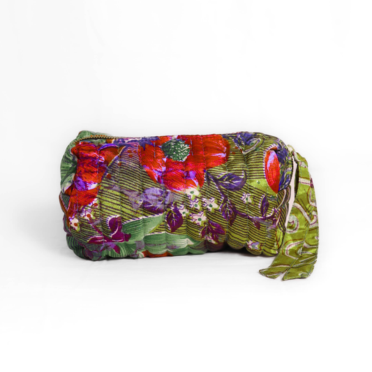 Quilted dumpling bag made from repurposed vintage sari fabric with stitched detailing and a structured rectangular shape. The bag features a zip closure and a fabric tie