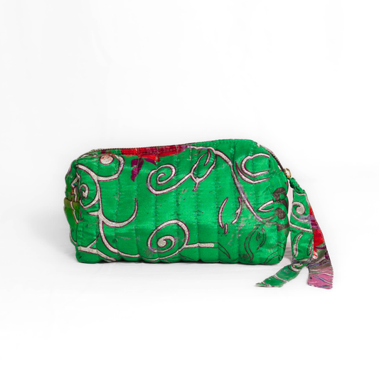 Quilted dumpling bag made from repurposed vintage sari fabric with stitched detailing and a structured rectangular shape. The bag features a zip closure and a fabric tie