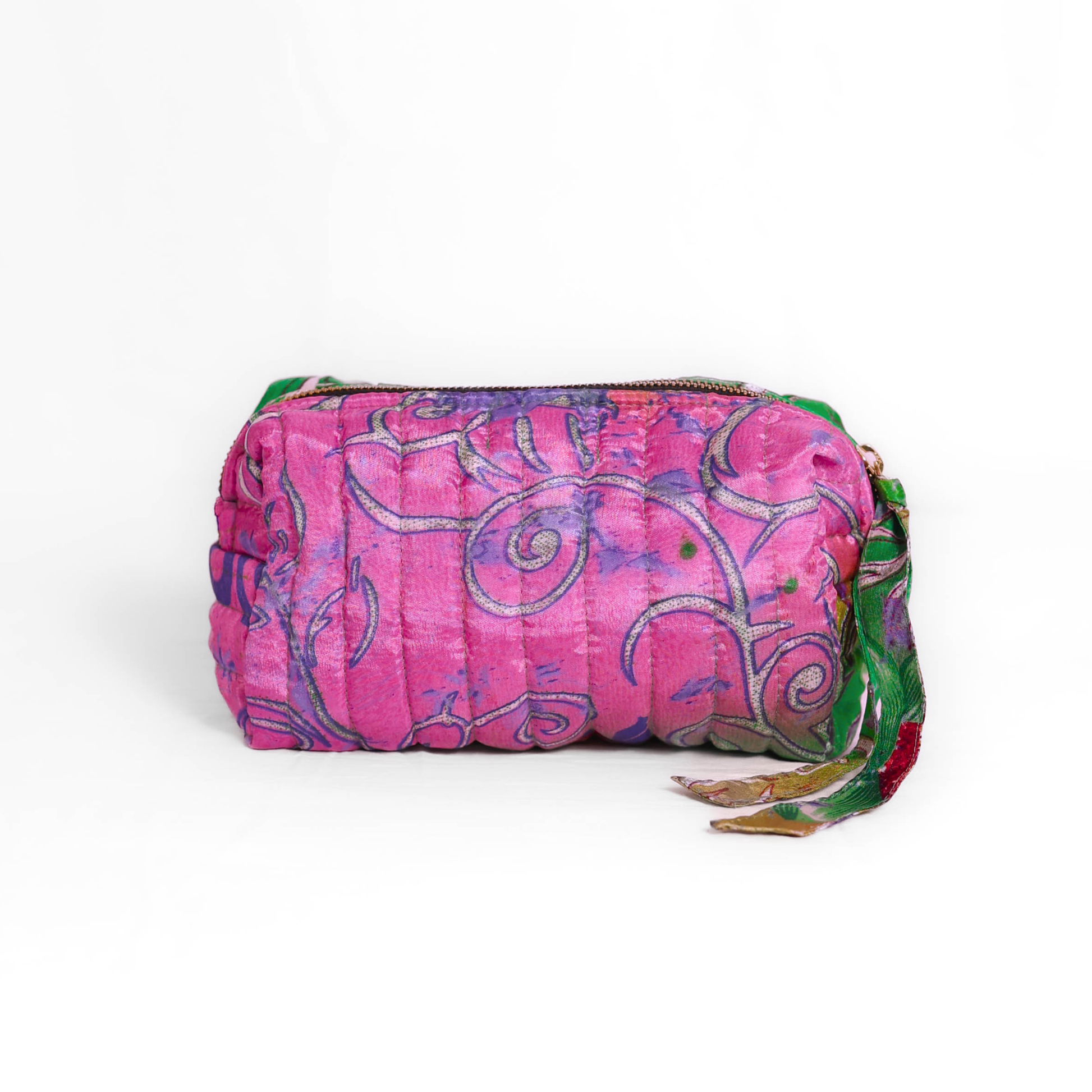 Quilted dumpling bag made from repurposed vintage sari fabric with stitched detailing and a structured rectangular shape. The bag features a zip closure and a fabric tie