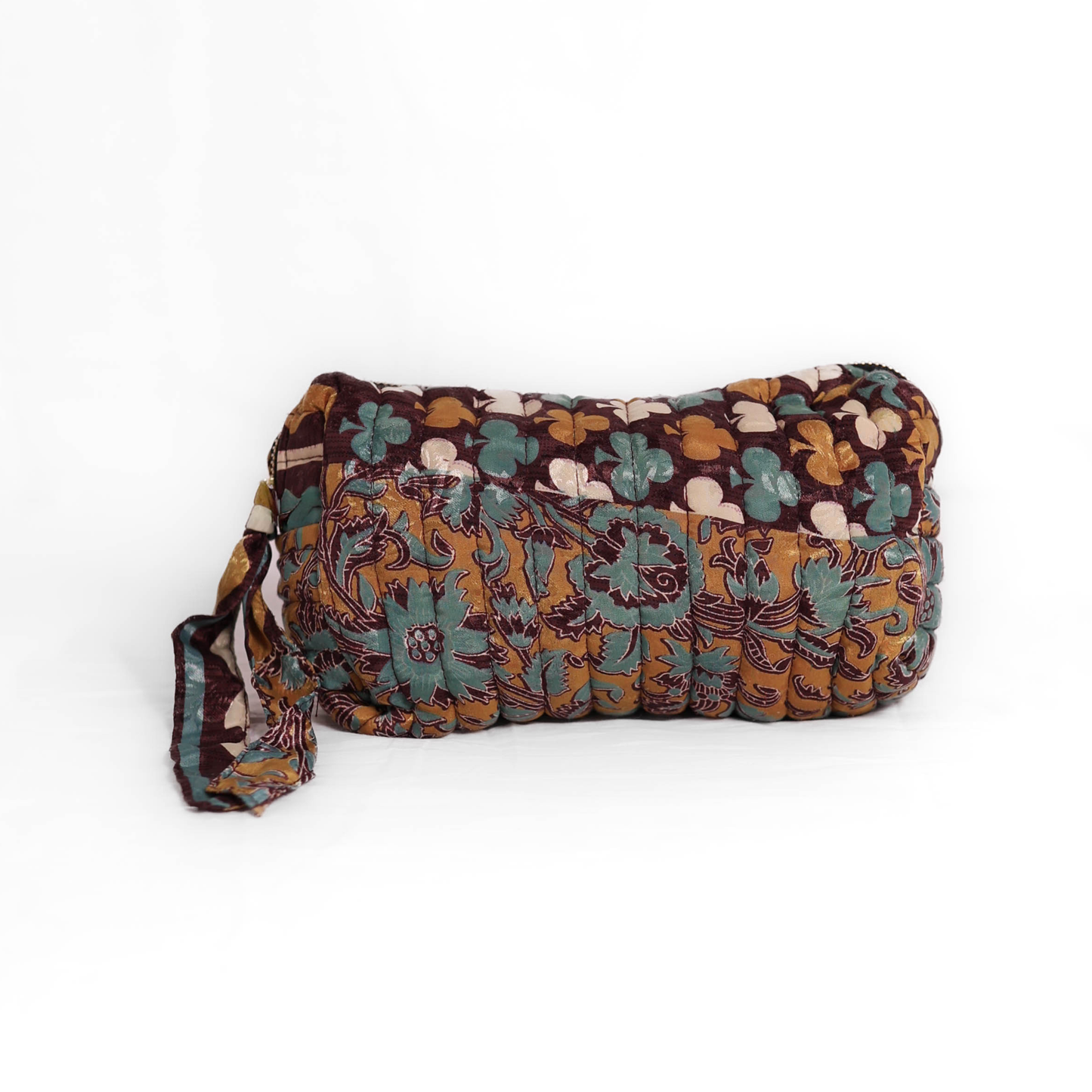 Quilted dumpling bag made from repurposed vintage sari fabric with stitched detailing and a structured rectangular shape. The bag features a zip closure and a fabric tie