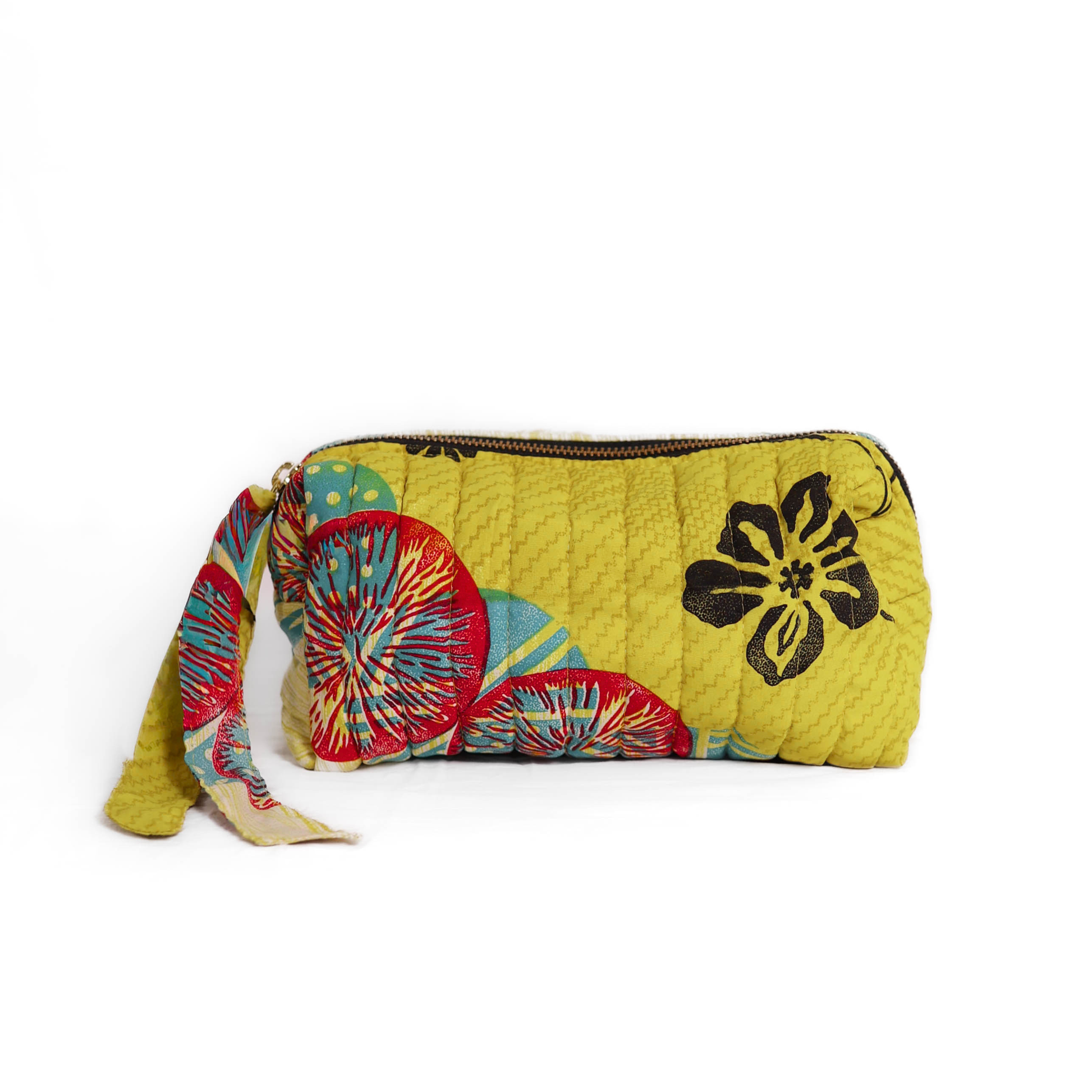Quilted dumpling bag made from repurposed vintage sari fabric with stitched detailing and a structured rectangular shape. The bag features a zip closure and a fabric tie