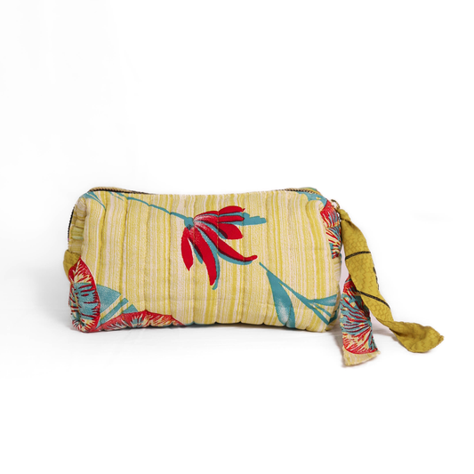 Quilted dumpling bag made from repurposed vintage sari fabric with stitched detailing and a structured rectangular shape. The bag features a zip closure and a fabric tie