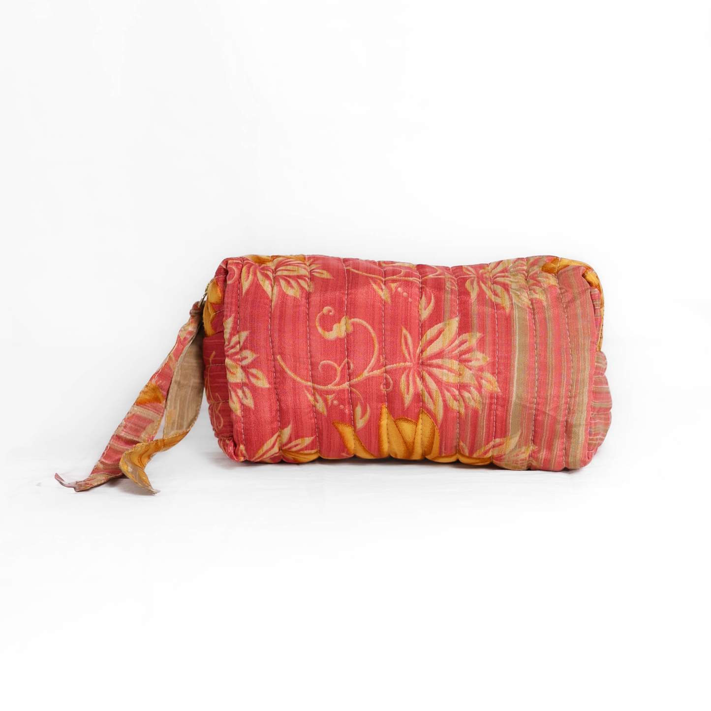Quilted dumpling bag made from repurposed vintage sari fabric with stitched detailing and a structured rectangular shape. The bag features a zip closure and a fabric tie
