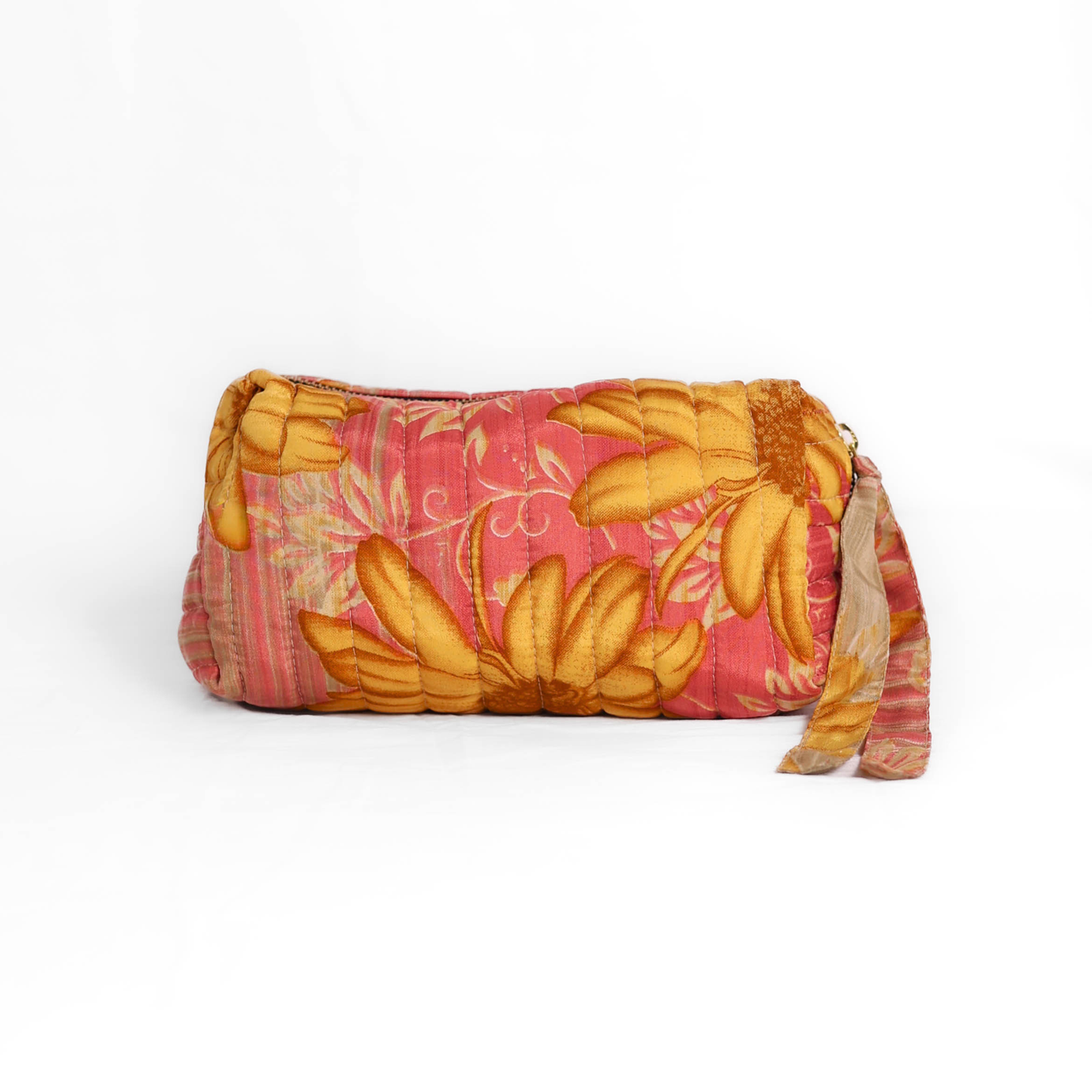 Quilted dumpling bag made from repurposed vintage sari fabric with stitched detailing and a structured rectangular shape. The bag features a zip closure and a fabric tie