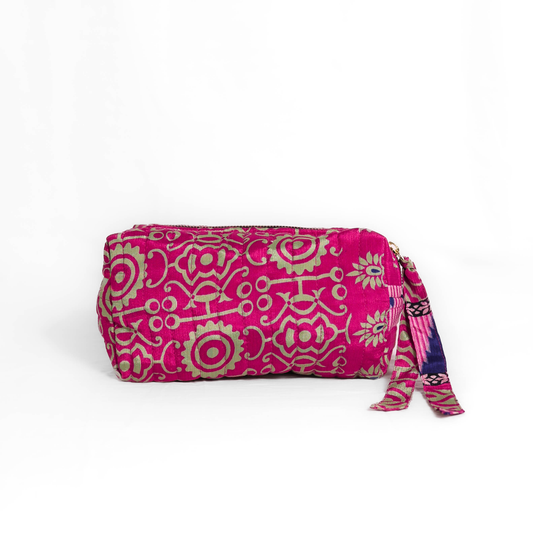 Quilted dumpling bag made from repurposed vintage sari fabric with stitched detailing and a structured rectangular shape. The bag features a zip closure and a fabric tie
