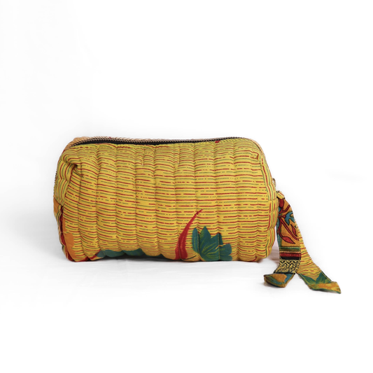 Quilted dumpling bag made from repurposed vintage sari fabric with stitched detailing and a structured rectangular shape. The bag features a zip closure and a fabric tie
