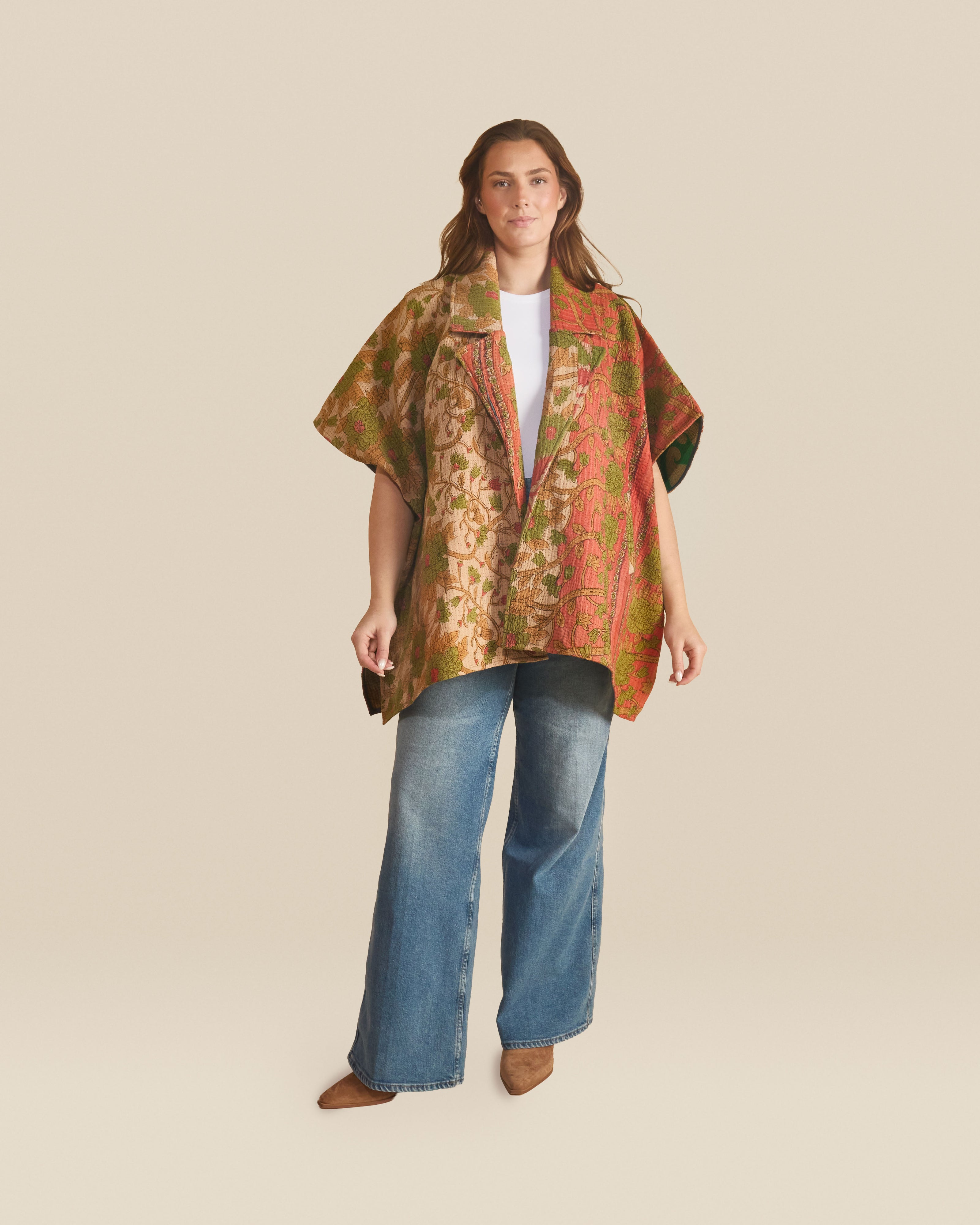 Lightweight open-front jacket with a relaxed, draped silhouette and short wide sleeves. The design features an intricate, tapestry-inspired pattern with floral and vine motifs in warm tones of rust, olive, and beige.