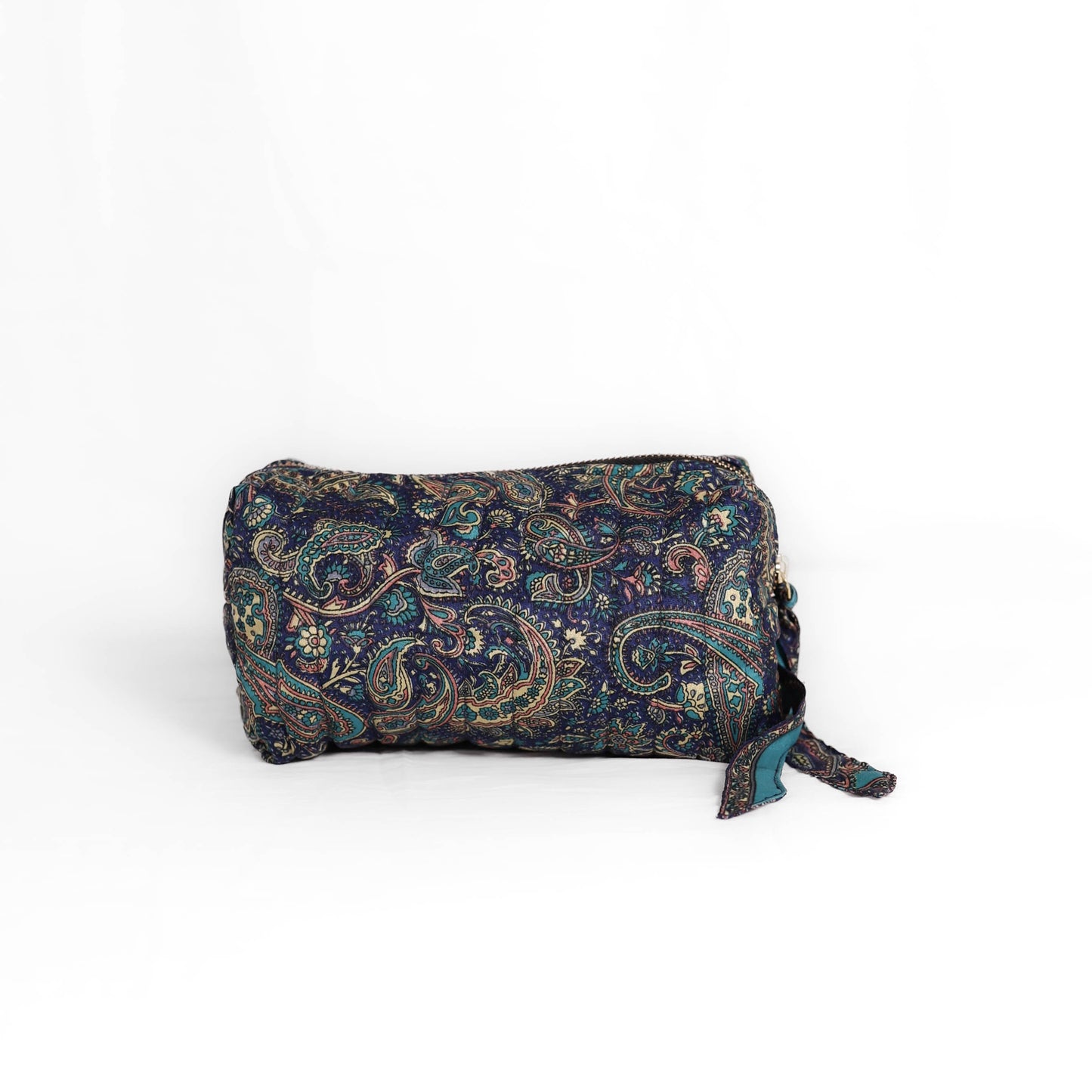 Quilted dumpling bag made from repurposed vintage sari fabric with stitched detailing and a structured rectangular shape. The bag features a zip closure and a fabric tie

