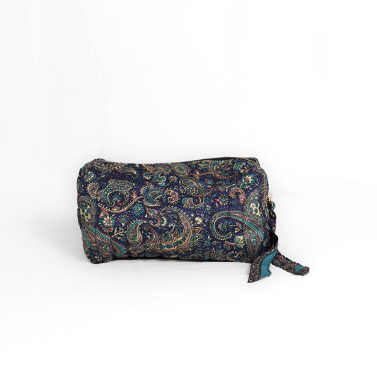 Quilted dumpling bag made from repurposed vintage sari fabric with stitched detailing and a structured rectangular shape. The bag features a zip closure and a fabric tie
