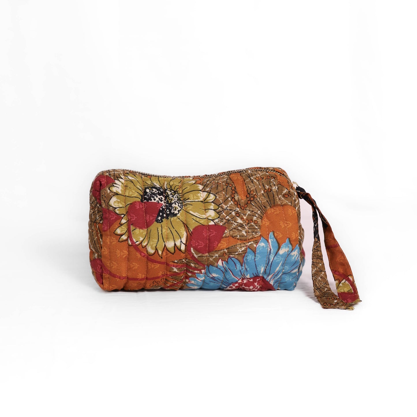Quilted dumpling bag made from repurposed vintage sari fabric with stitched detailing and a structured rectangular shape. The bag features a zip closure and a fabric tie