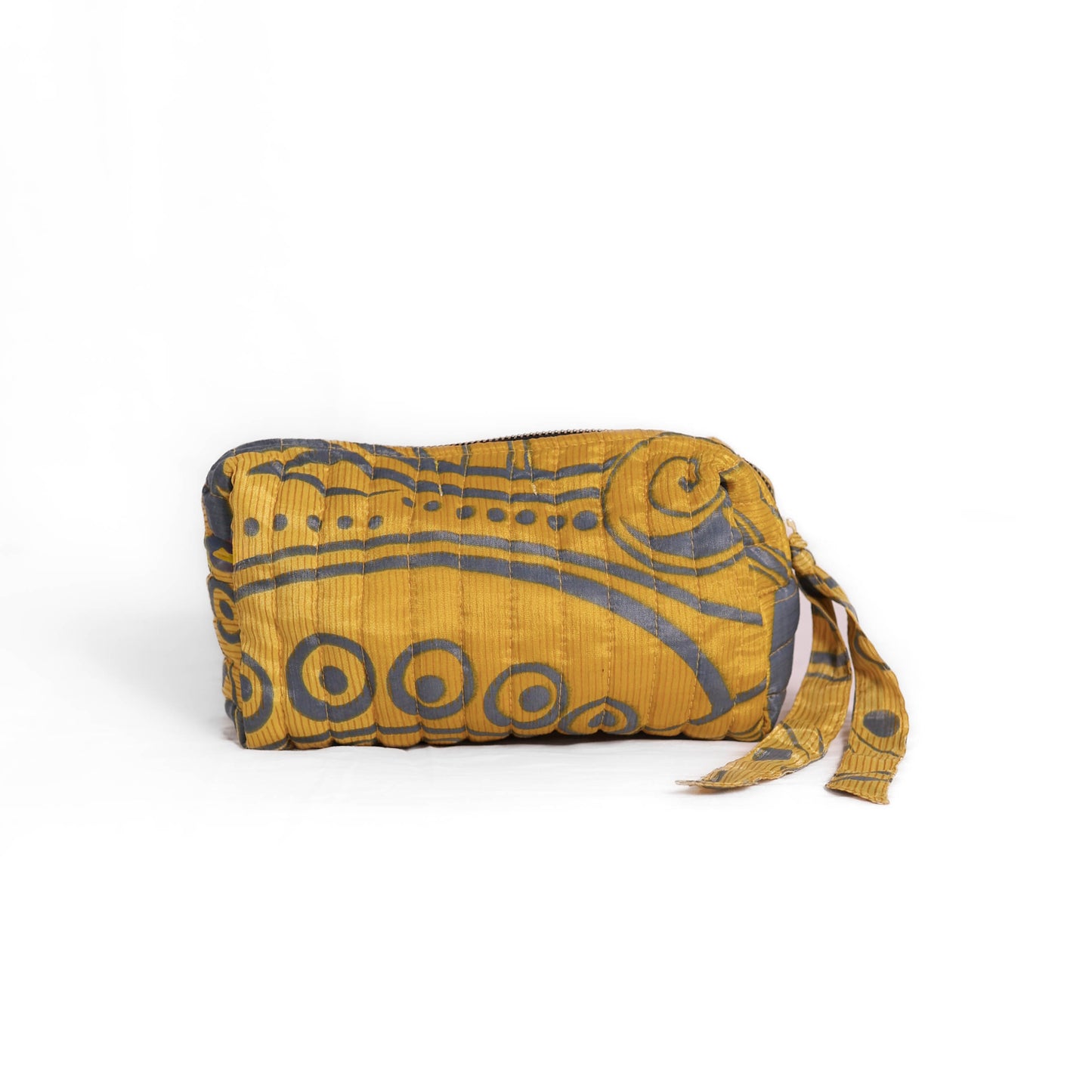 Quilted dumpling bag made from repurposed vintage sari fabric with stitched detailing and a structured rectangular shape. The bag features a zip closure and a fabric tie
