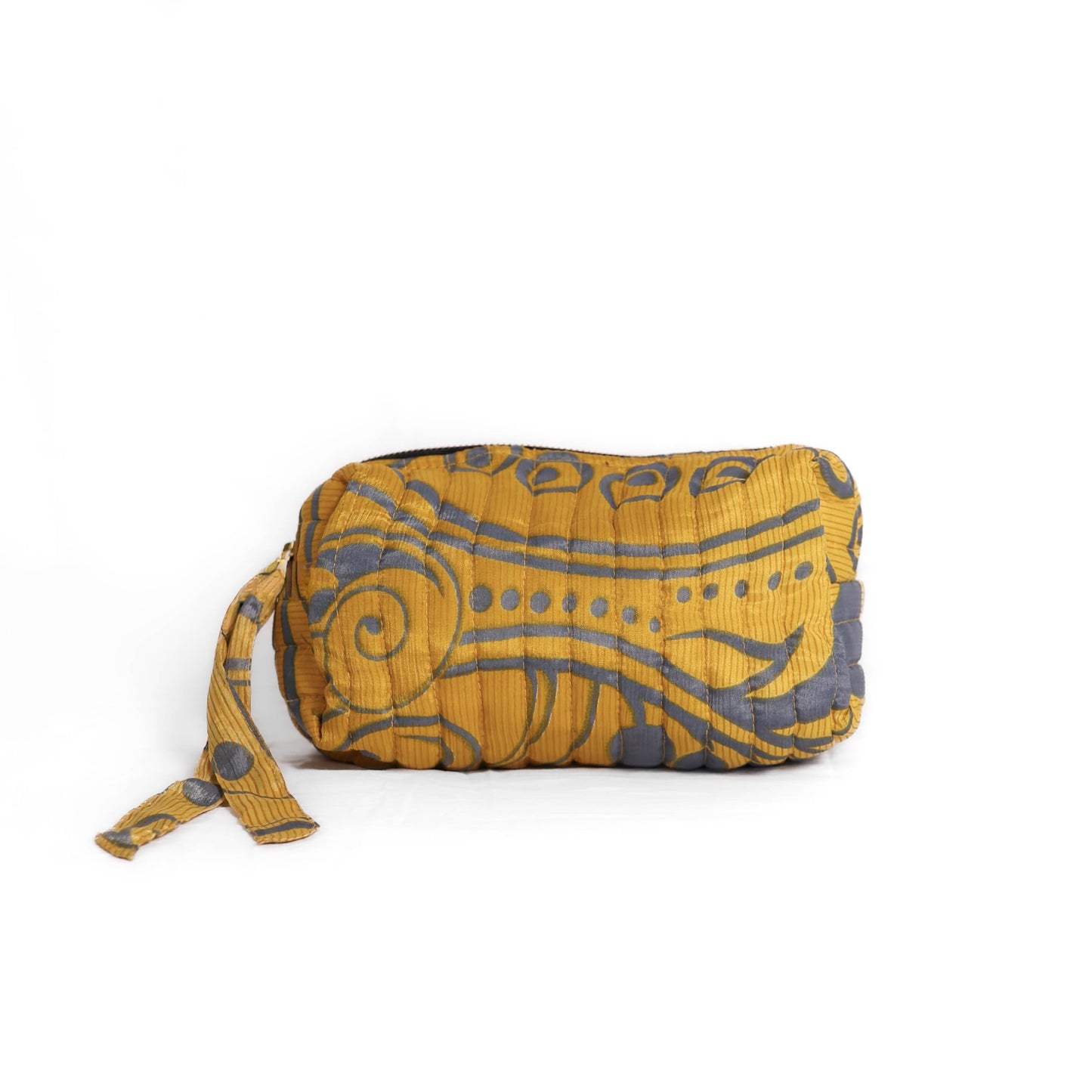 Quilted dumpling bag made from repurposed vintage sari fabric with stitched detailing and a structured rectangular shape. The bag features a zip closure and a fabric tie
