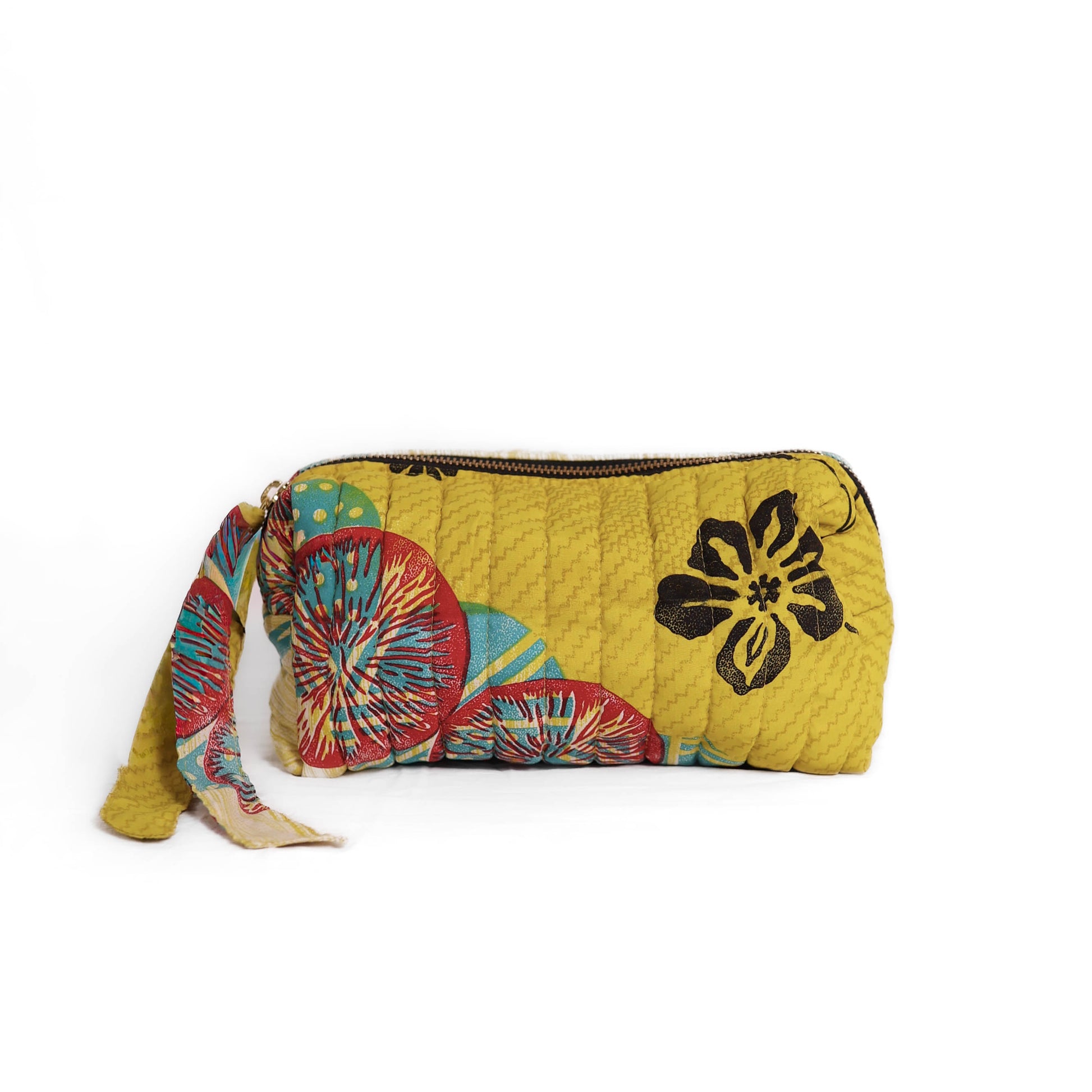 Quilted dumpling bag made from repurposed vintage sari fabric with stitched detailing and a structured rectangular shape. The bag features a zip closure and a fabric tie
