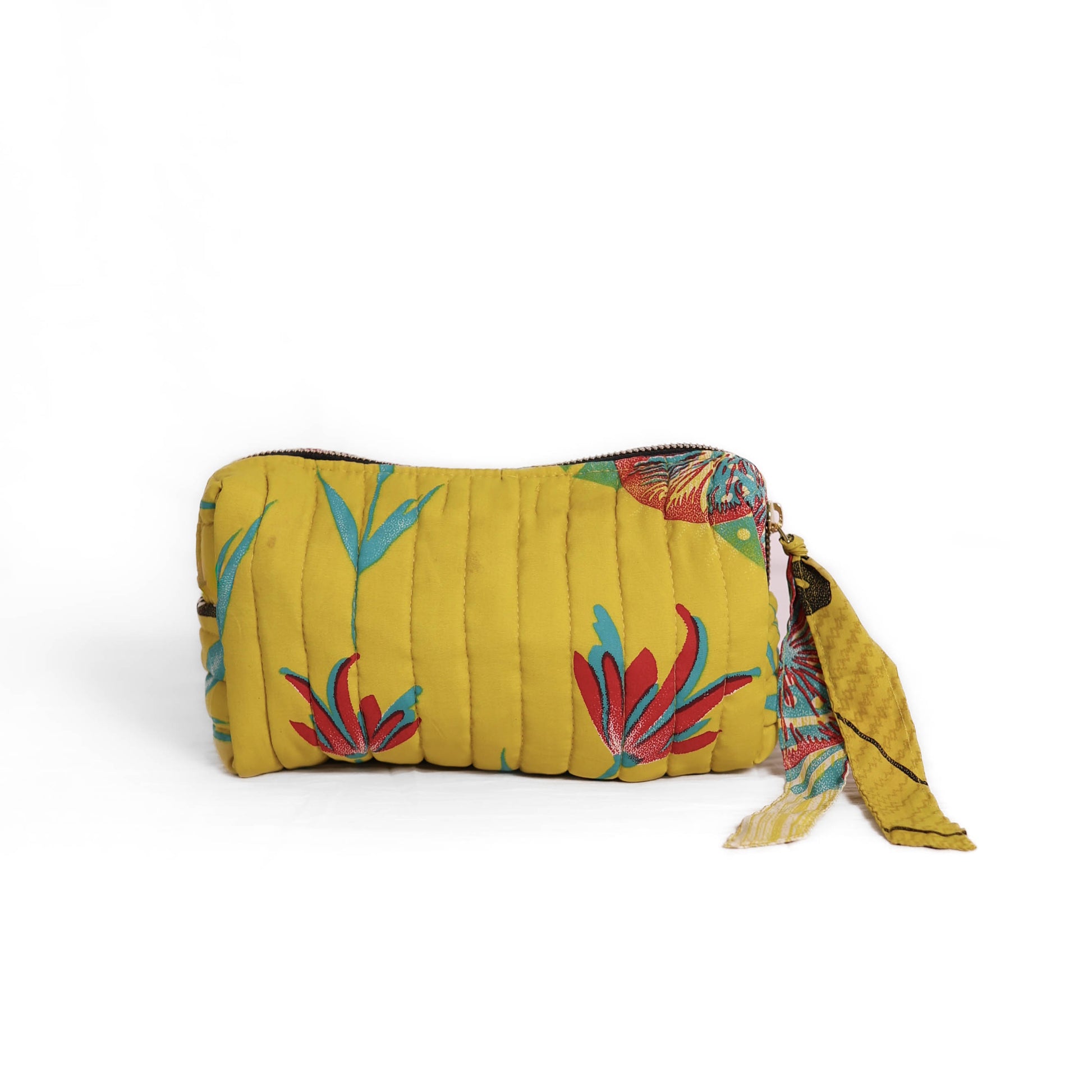 Quilted dumpling bag made from repurposed vintage sari fabric with stitched detailing and a structured rectangular shape. The bag features a zip closure and a fabric tie
