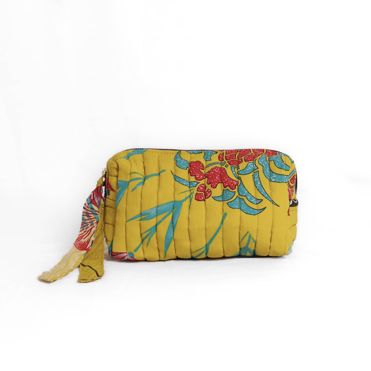 Quilted dumpling bag made from repurposed vintage sari fabric with stitched detailing and a structured rectangular shape. The bag features a zip closure and a fabric tie
