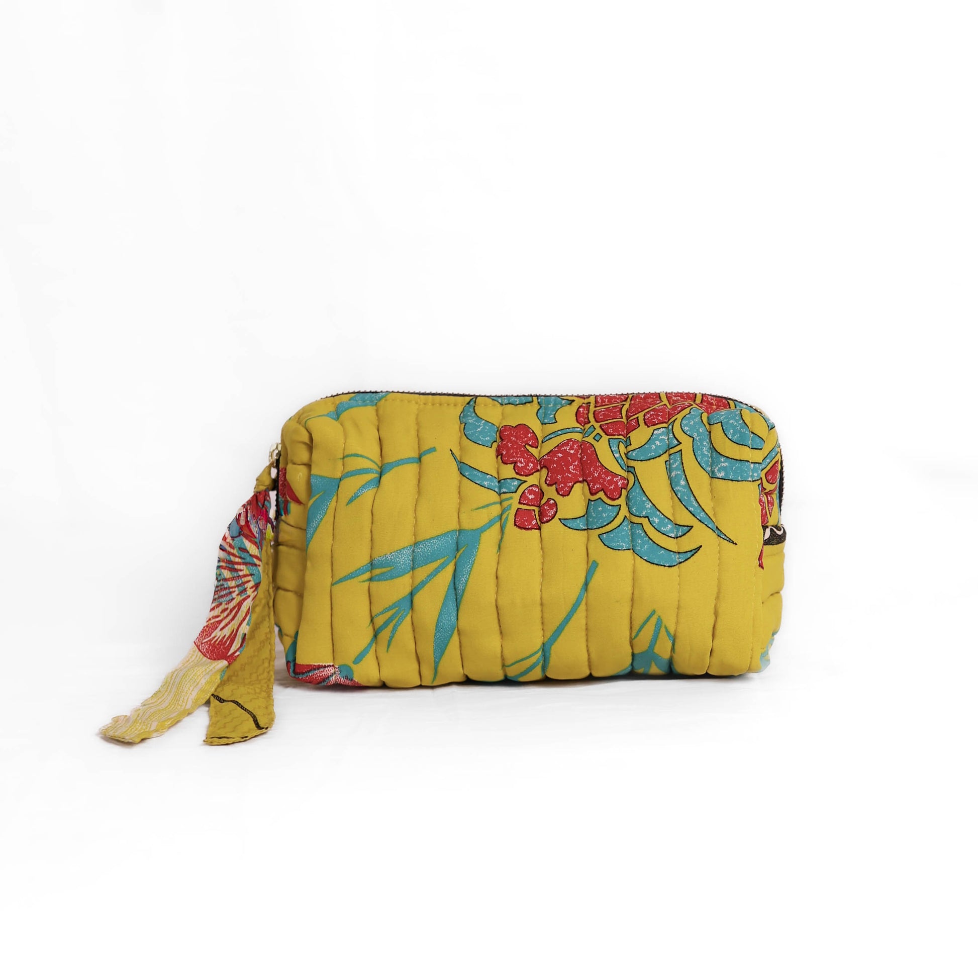 Quilted dumpling bag made from repurposed vintage sari fabric with stitched detailing and a structured rectangular shape. The bag features a zip closure and a fabric tie
